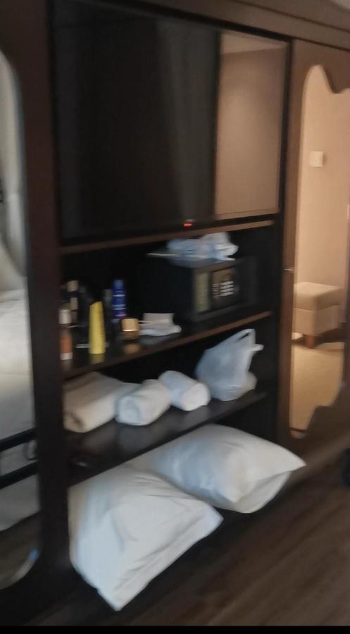 Buona Vitta Gramado Resort & Spa By Gramado Parks מראה חיצוני תמונה The photo shows a piece of furniture, likely a shelving unit or cabinet, with several items on it. There is a television mounted on top. Below the TV, there is a microwave and a small safe. The shelves contain various toiletries and personal care pro