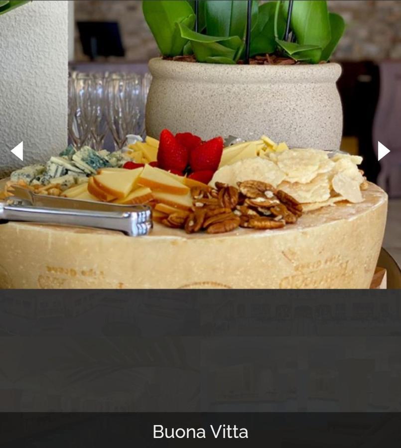 Buona Vitta Gramado Resort & Spa By Gramado Parks מראה חיצוני תמונה The photo displays a beautiful cheese platter. It features a large round cheese wheel as the base, surrounded by various types of cheeses including soft and hard varieties. There are also some crackers or crisps, along with nuts, particularly pecans.