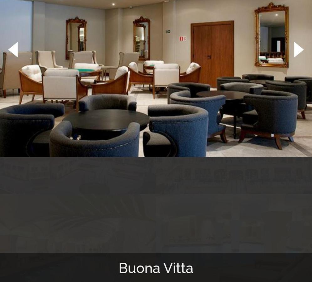 Buona Vitta Gramado Resort & Spa By Gramado Parks מראה חיצוני תמונה The photo shows a modern, elegantly designed lounge or waiting area. It features several circular seating arrangements with dark blue armchairs surrounding black tables. In the background, there are light-colored lounge chairs and a wooden door leadi
