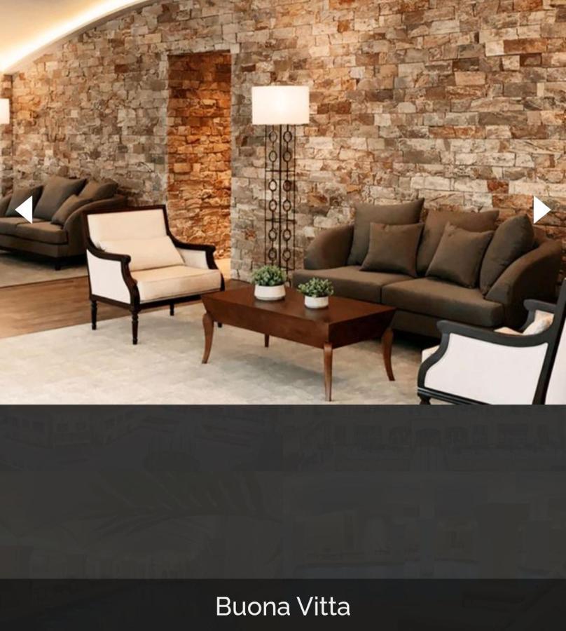 Buona Vitta Gramado Resort & Spa By Gramado Parks מראה חיצוני תמונה The image shows a stylish living room setting. There are two sofas: one is a dark brown color, and the other is a cream color with dark wooden accents. In the center, there is a wooden coffee table with a smooth finish and decorative plants on top. T