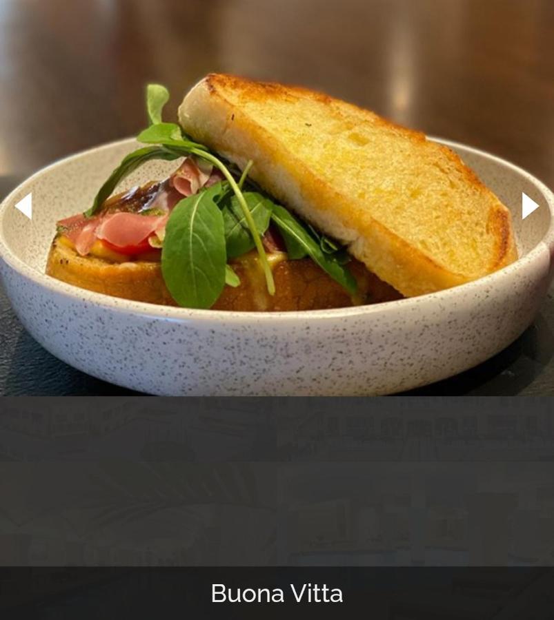 Buona Vitta Gramado Resort & Spa By Gramado Parks מראה חיצוני תמונה The photo shows a dish presented in a round, speckled bowl. It features a slice of toasted bread resting on top of a combination of ingredients beneath. The ingredients include leafy greens and slices of what appears to be cured meat, possibly ham. T