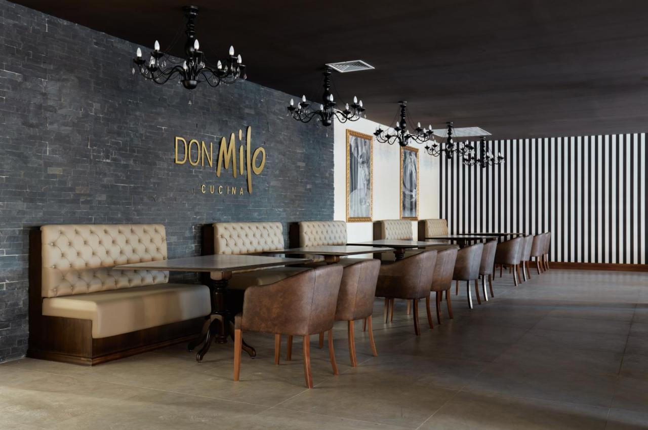 Buona Vitta Gramado Resort & Spa By Gramado Parks מראה חיצוני תמונה The photo showcases an interior of a restaurant named "Don Milo." The design features a modern and sophisticated look with a mix of textures and colors. 

On one side, there are upholstered booths in a neutral tone, creating a comfortable dining area