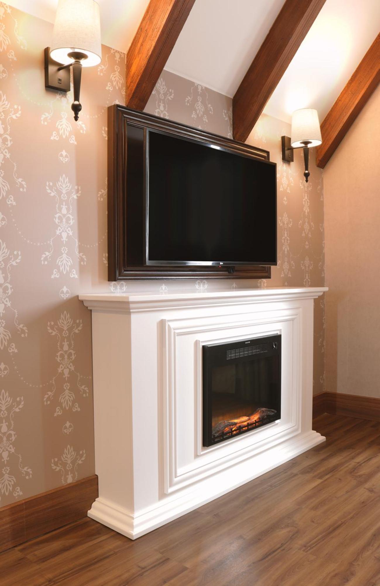 Buona Vitta Gramado Resort & Spa By Gramado Parks מראה חיצוני תמונה The image shows a modern living room setup featuring a white mantel with an electric fireplace. Above the mantel, there is a large flat-screen television mounted on the wall. The fireplace has a glass front and displays a realistic flame effect, crea